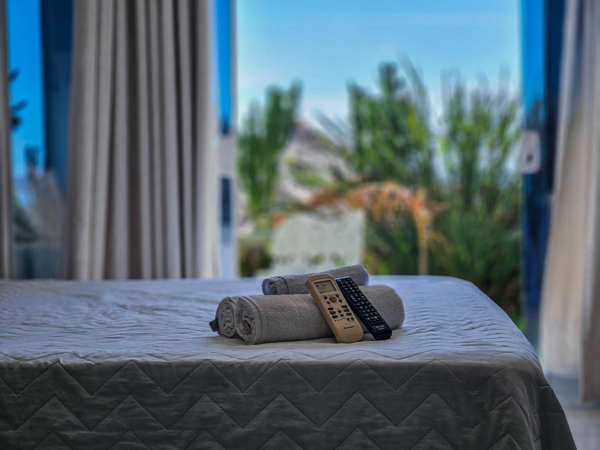 فندق Bella Vista Ocean View Búzios المظهر الخارجي الصورة A bed with a remote control and a towel